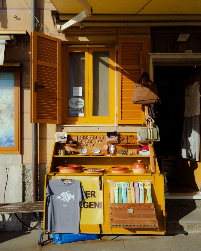 A yellow shopfront displays various goods.