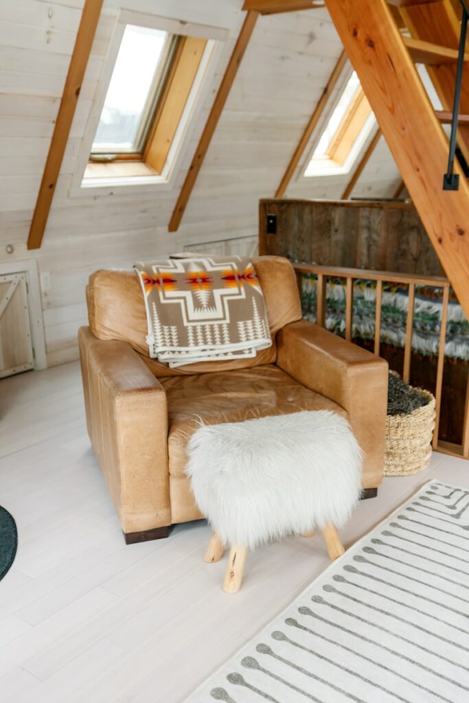 Cozy room featuring an armchair and ottoman.